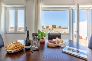 een tafel met een fles wijn en brood erop bij Pepita del mare in Alghero