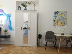a white door in a room with a table and a chair at Lionas Central Apartment in Bistriţa