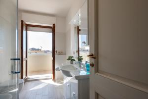 een badkamer met een wastafel, een spiegel en een bad bij Pepita del mare in Alghero +44 foto's