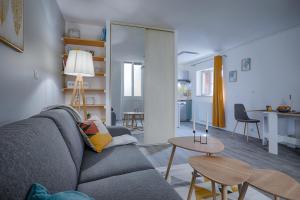uma sala de estar com um sofá e uma mesa em La chopine - grand studio, centre historique, hôtel de ville em Romans-sur-Isère