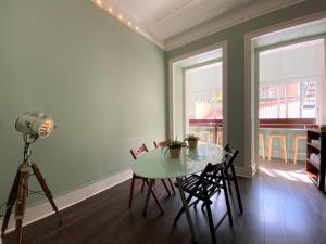 a dining room with a table and chairs and a camera at Green Heart Hostel in Lisbon
