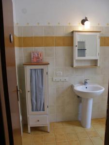 uma pequena casa de banho com um lavatório e um espelho em Casetta n.2 con piscina em Sarola