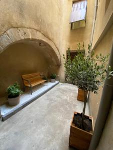 um pátio com um banco e vasos de plantas em La chopine - grand studio, centre historique, hôtel de ville em Romans-sur-Isère