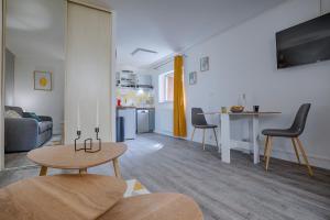 uma sala de estar com uma mesa e uma cozinha em La chopine - grand studio, centre historique, hôtel de ville em Romans-sur-Isère