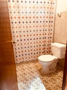 a bathroom with a toilet and a shower curtain at El paraíso de Zacatlán, Departamento con Terraza, 10 pax in Zacatlán