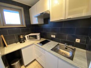 a small kitchen with a sink and a microwave at Beau Sejour in Heuvelland
