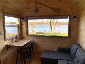 Habitación con sofá, mesa y ventana en Shady Haven - Tiny Home 1, en Bellevue