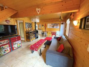 a living room with a couch and a tv in a cabin at Chalet 'Le Grand Pré' Gérardmer in Gérardmer