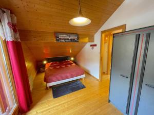 a bedroom with a bed in a wooden room at Chalet 'Le Grand Pré' Gérardmer in Gérardmer