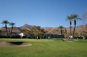 two people playing golf on a green with palm trees at WorldMark Palm Springs - Plaza Resort and Spa in Palm Springs