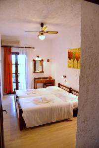 a bedroom with a bed and a ceiling fan at Filoxenia Villa in Koutsounari