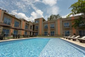 a swimming pool in front of a building at Hotel Natural Hill's by H&R in Villeta
