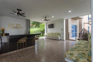 a living room with a bar and a couch at Hotel Natural Hill's by H&R in Villeta