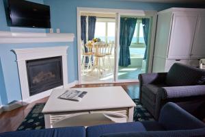 a living room with a fireplace and a table and chairs at Edgewater Beach Resort, a VRI resort in Dennis Port