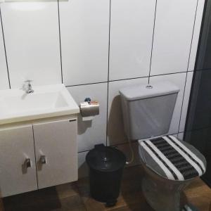 ein weißes Bad mit einem Waschbecken und einem WC in der Unterkunft Chalé Portal Lazer in Gonçalves