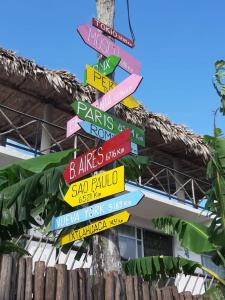 a street sign with many signs on a tree at La Casa de las Aves in Bacalar