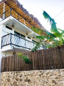 a house with a fence and a balcony at La Casa de las Aves in Bacalar