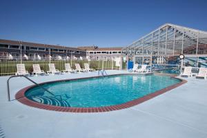 a large swimming pool with chairs and a building at Edgewater Beach Resort in Dennis Port