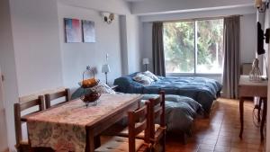 sala de estar con cama, mesa y comedor en Departamento Costanera Bariloche en San Carlos de Bariloche