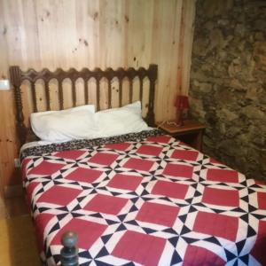a bedroom with a bed with a red and white quilt at Casa Branca in Lousã