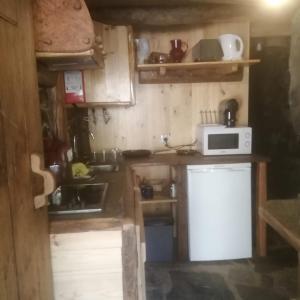 a small kitchen with a microwave and a sink at Casa Branca in Lousã