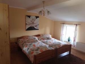 1 dormitorio con 1 cama con una pintura floral en la pared en Apartment Lietzow/Rügen/Insel Rügen 2913, en Lietzow