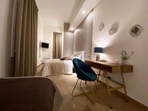 - une chambre avec un lit et un bureau avec une chaise dans l'établissement Palazzo Bianchi - Trani, à Trani