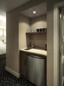 a bathroom with a sink and a bed in a room at The Malcolm Hotel in Canmore