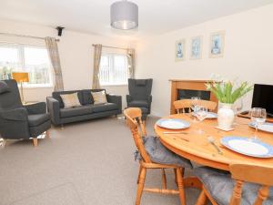 a living room with a wooden table and chairs at Broadclyst Cottage in Exeter
