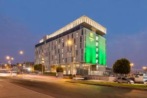 um grande edifício numa rua da cidade à noite em Holiday Inn - Lima Airport, an IHG Hotel em Lima