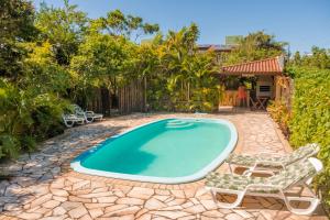 a swimming pool with two lounge chairs and a swimming pool at Hospedaria Nativa in Praia do Rosa
