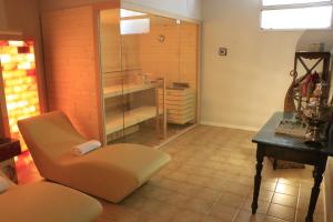 y baño con ducha, silla y mesa. en Albergo & Ristorante Selvatico, en Rivanazzano Terme