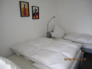 um quarto com duas camas brancas e um candeeiro em Berliner-Hof-HOF-406 em Scharbeutz