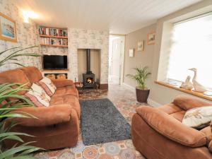 a living room with two couches and a fireplace at Rose Cottage in Deal