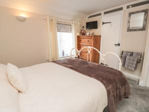 a bedroom with a large white bed and a window at Rose Cottage in Deal