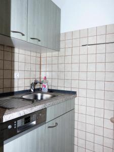 een keuken met een wastafel en een betegelde muur bij Berliner-Hof-HOF-407 in Scharbeutz