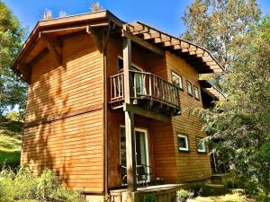 uma casa de madeira com uma varanda ao lado em Elementos Eco Lodge em Pucón