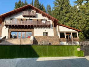 a house with a green fence in front of it at Platinvm B&B in Predeal