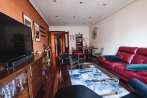 a living room with a red couch and a table at El Rosal de Oviedo in Oviedo