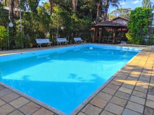 a large blue swimming pool with a gazebo at Sítio Esperança e Fé in Ribeirão das Neves