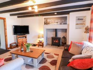 a living room with a couch and a fireplace at Kings Cottage in Alston