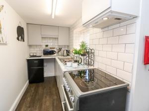 a kitchen with a sink and a stove at Kings Cottage in Alston