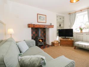 a living room with a couch and a fireplace at Shamrock Cottage in Grange Over Sands