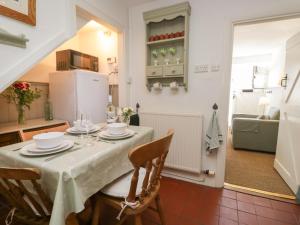 a kitchen and dining room with a table and chairs at Shamrock Cottage in Grange Over Sands