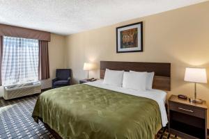 a hotel room with a large bed and a chair at Quality Inn Duluth - Atlanta Northeast in Duluth +23 photos