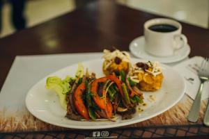 a plate of food on a table with a cup of coffee at Hotel Las Peñas in Guayaquil
