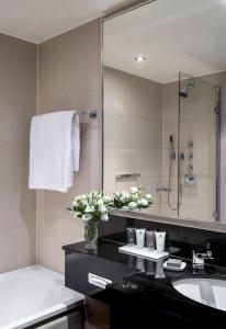 a bathroom with a sink, mirror, and towel rack at The Bristol Hotel in Bristol