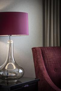 a glass lamp sitting on a table next to a chair at The Bristol Hotel in Bristol