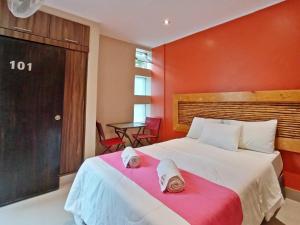 Un dormitorio con una cama grande con una pared roja. en Hotel Sand and Lake, en Ica