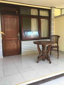 a wooden table and a chair next to a door at Gina's guest house in Sanur
